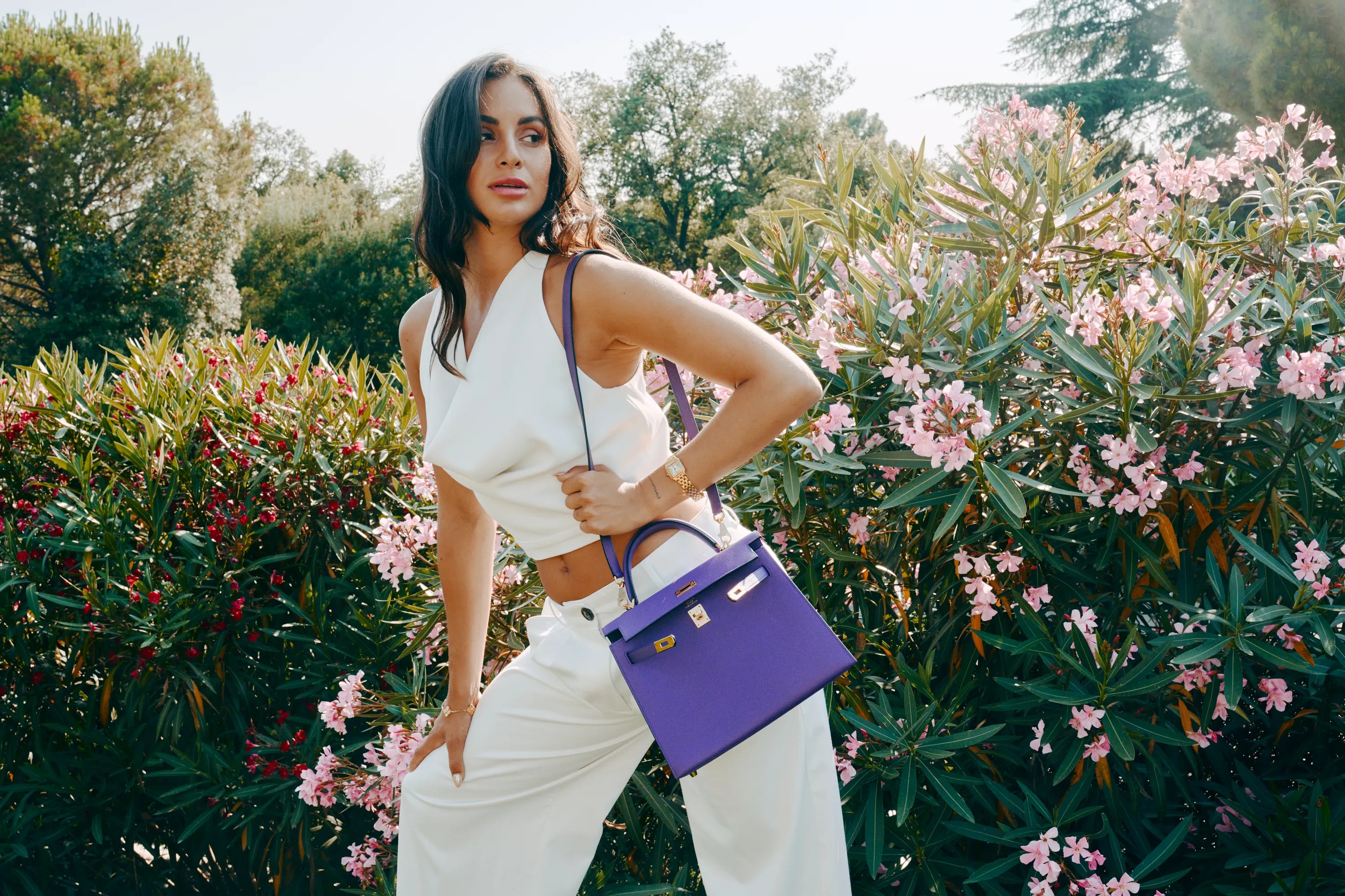 Iris Epsom Hermès Kelly bag styled in a summer garden campaign image