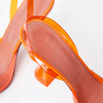 Amina Muaddi Rosie Glass PVC orange transparent slingback heels with crystal bow detail