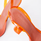 Amina Muaddi Rosie Glass PVC orange transparent slingback heels with crystal bow detail