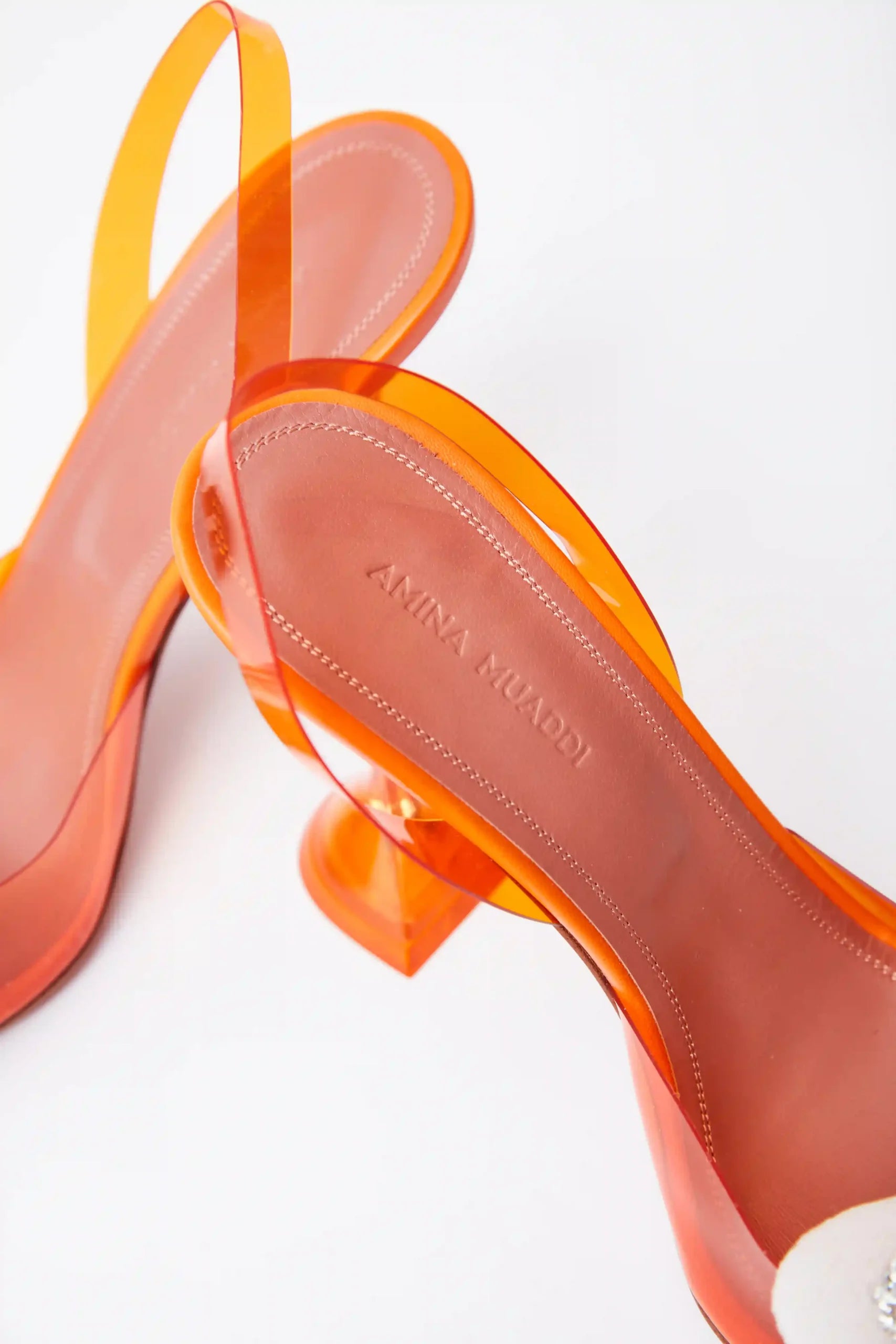 Amina Muaddi Rosie Glass PVC orange transparent slingback heels with crystal bow detail