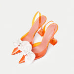 Amina Muaddi Rosie Glass PVC orange transparent slingback heels with crystal bow detail