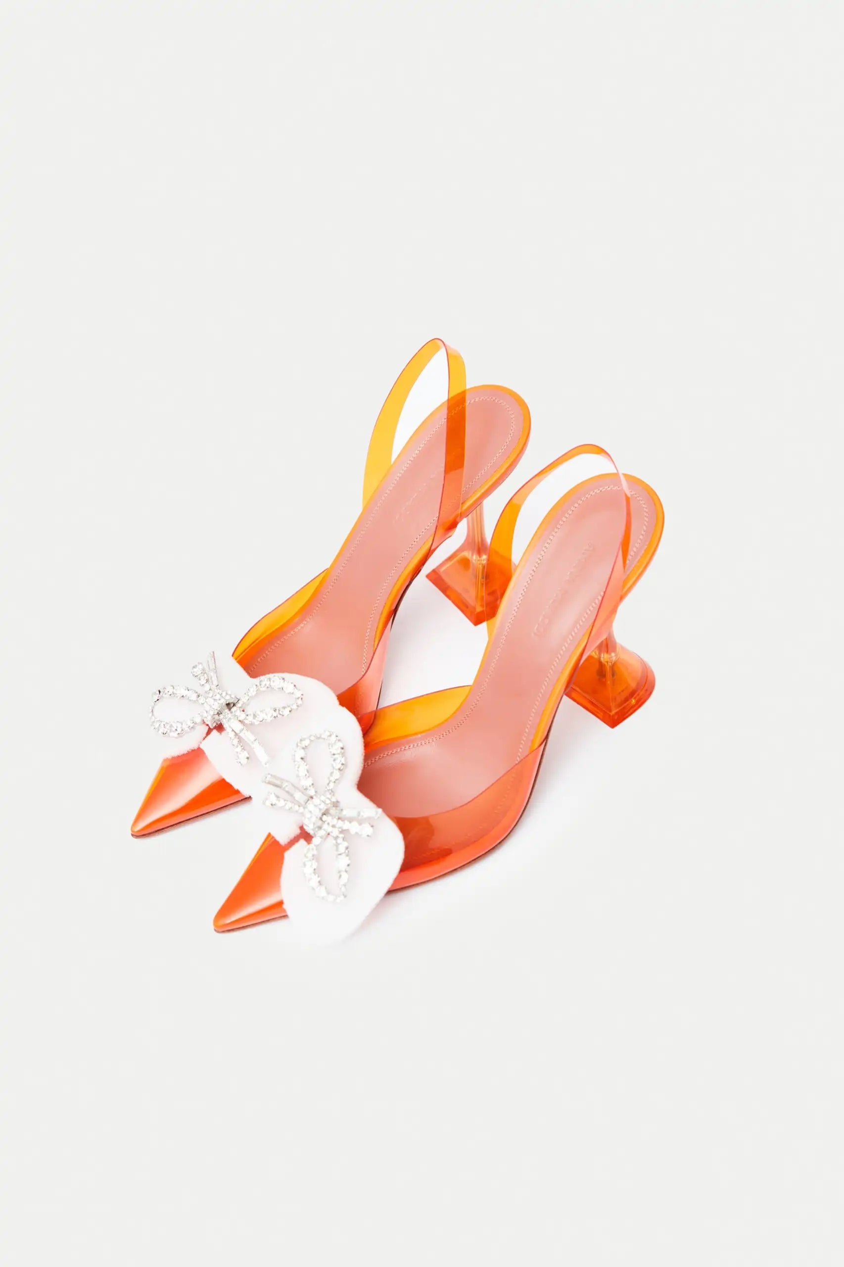 Amina Muaddi Rosie Glass PVC orange transparent slingback heels with crystal bow detail