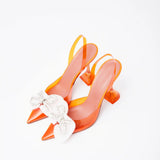 Amina Muaddi Rosie Glass PVC orange transparent slingback heels with crystal bow detail