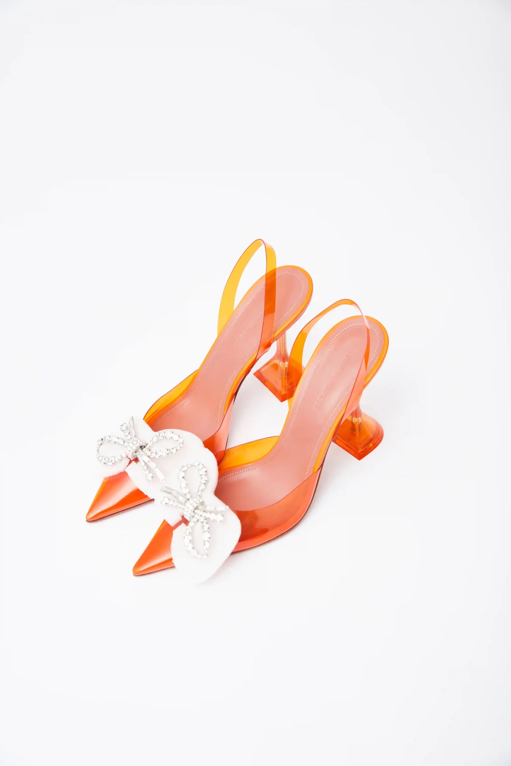Amina Muaddi Rosie Glass PVC orange transparent slingback heels with crystal bow detail