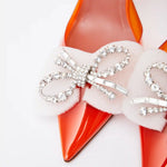 Amina Muaddi Rosie Glass PVC orange transparent slingback heels with crystal bow detail