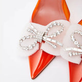 Amina Muaddi Rosie Glass PVC orange transparent slingback heels with crystal bow detail
