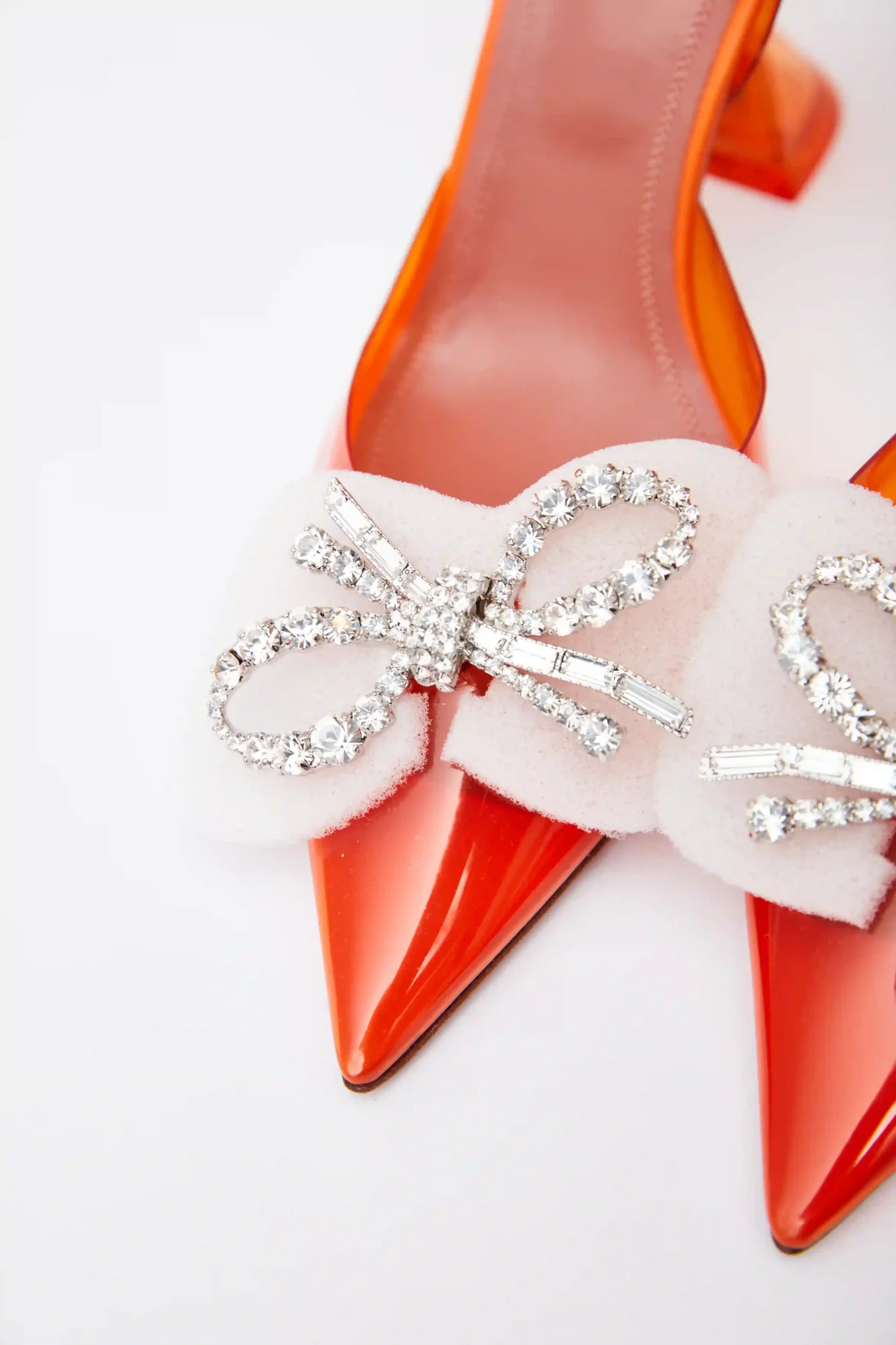 Amina Muaddi Rosie Glass PVC orange transparent slingback heels with crystal bow detail